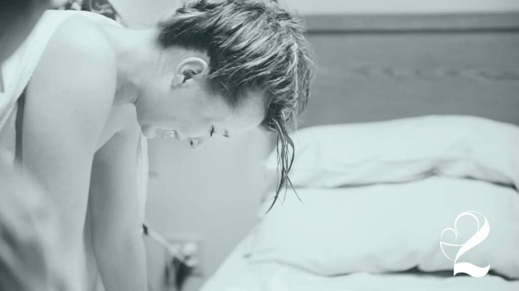 mom in labor leaning over bed