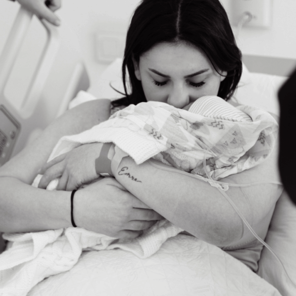 mom kissing baby after birth