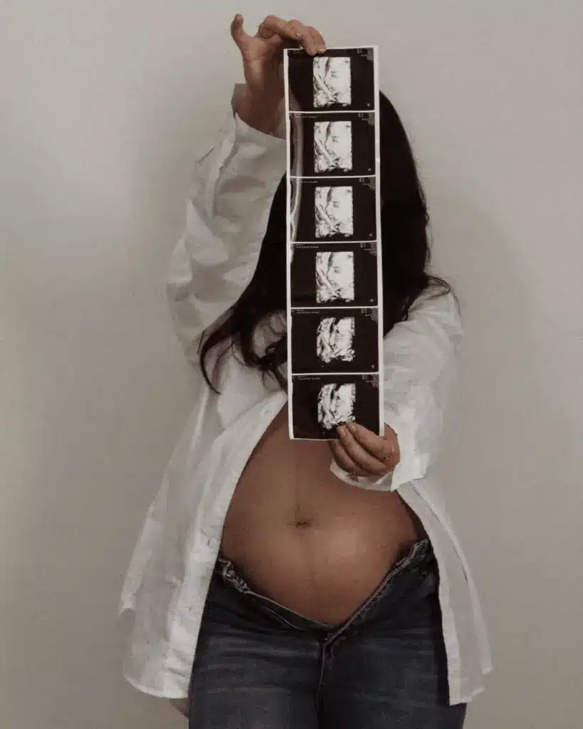 woman holding ultrasound strip pregnant in 3rd trimester